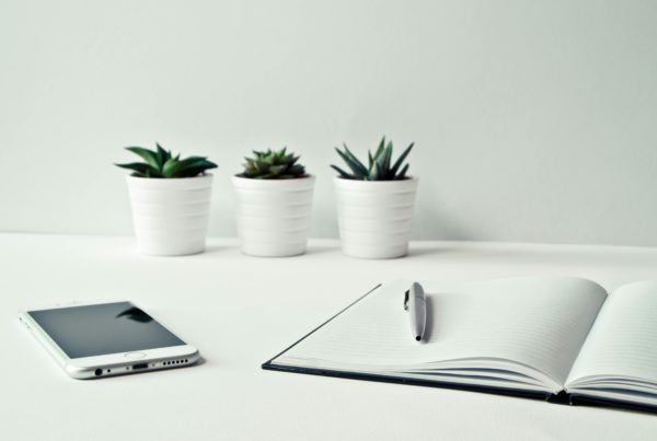 Workspace featuring a laptop and phone, emphasizing the role of technology in supporting mental health practices